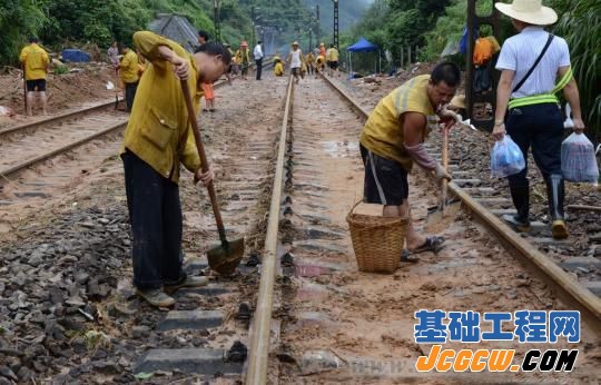 工人们忙于清理路基上的淤泥