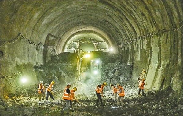 图为建设者正在实现贯通的新宾隧道内作业。本报记者 查金辉 摄